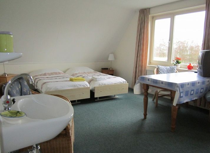 B&B van der Wal in Den Burg Texel, charming bed and breakfast with spacious garden and Dutch flag, ideal for a relaxing stay.