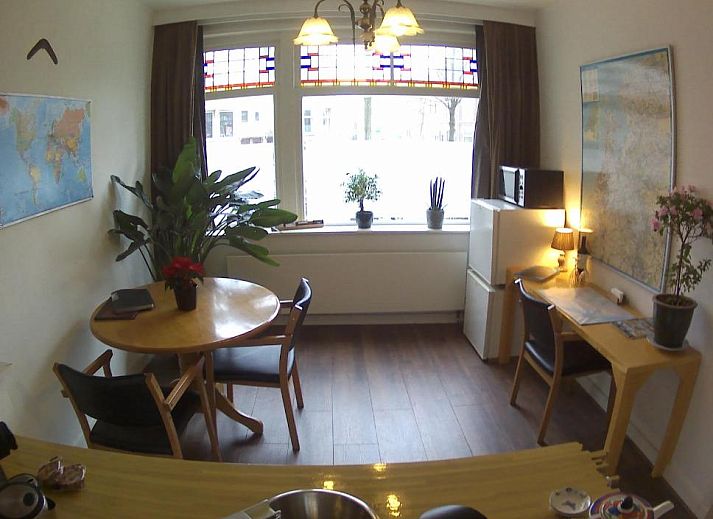 Modern kitchenette in Imagine My B&B Rotterdam with brick wall and wooden accents.