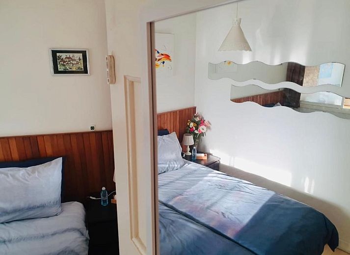 Modern kitchenette in Imagine My B&B Rotterdam with brick wall and wooden accents.