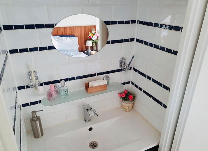 Modern kitchenette in Imagine My B&B Rotterdam with brick wall and wooden accents.