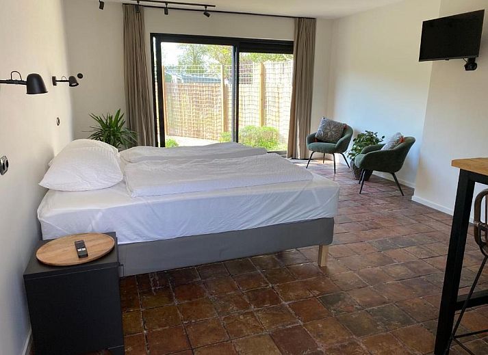 Helles Schlafzimmer im Bed & Breakfast Zeeland, Noordwelle, mit bequemem Bett und Fliesenboden.