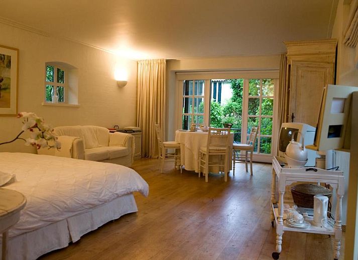 B&B Veerhoeve in Sluis, Zeeland, bietet einen charmanten Aussenbereich mit gruenem Garten und Backsteinfassade.