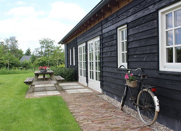 Gemuetliche Ecke im Ferienhaus in Westendorp, Achterhoek, mit Holzschrank und Gartenblick.