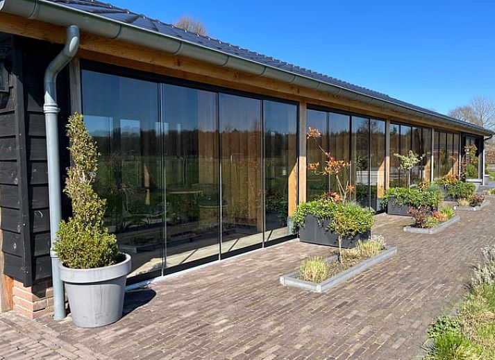 Geniet van de veranda bij Vakantiehuisje in Garderen, Veluwe, met uitzicht op de groene omgeving.