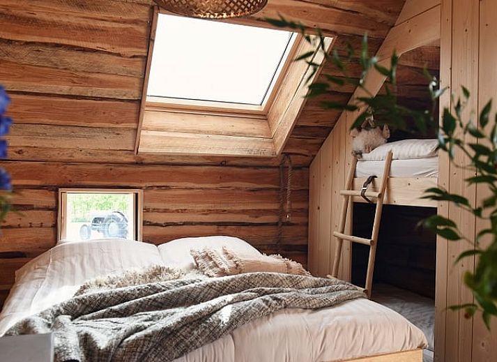 Speeltuin bij Huisje in Oosterwolde, Veluwe, Gelderland met houten speeltoestellen en groen uitzicht.