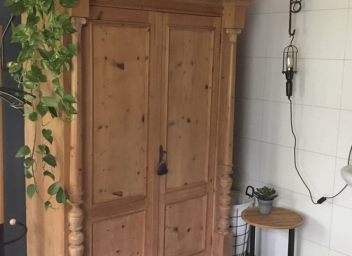 Gezellige zithoek in Vakantiehuis in Oene, Veluwe, met comfortabele stoelen en bloemen voor een ontspannen verblijf.