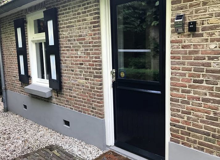 Gezellige zithoek in Vakantiehuis in Oene, Veluwe, met comfortabele stoelen en bloemen voor een ontspannen verblijf.