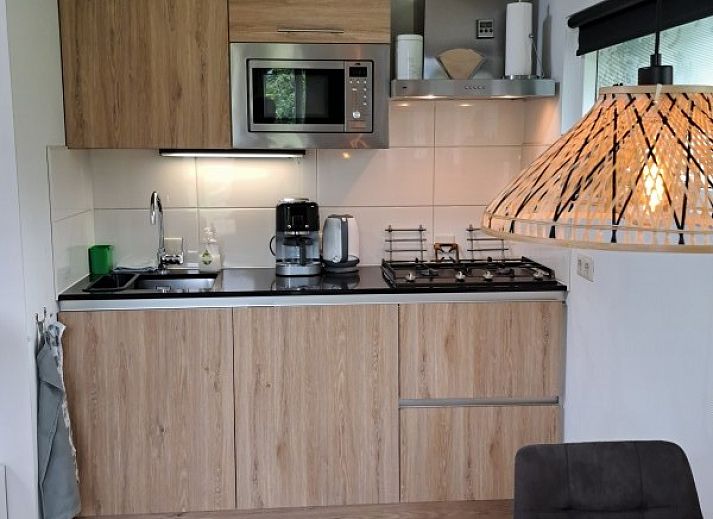 Prachtige tuin bij bed & breakfast DE DOBBE in Glimmen, Groningen met kleurrijke bloemen en zitplekken.