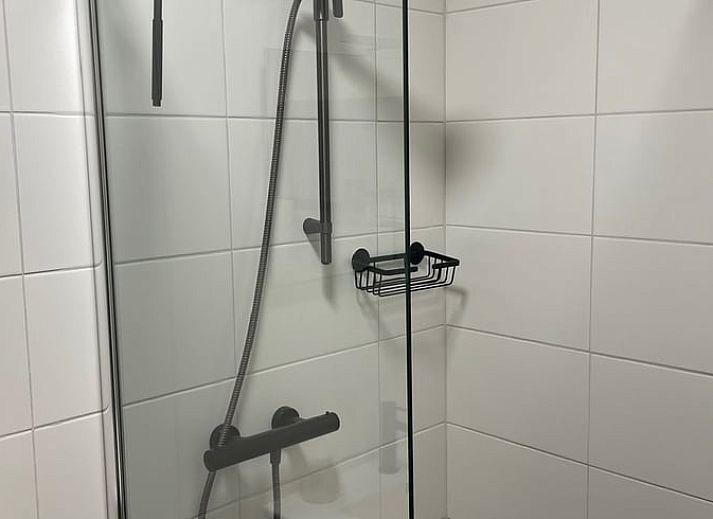 Vakantiehuisje in Noordwijk met rieten dak, omgeven door groen in Zuidwest Groningen.