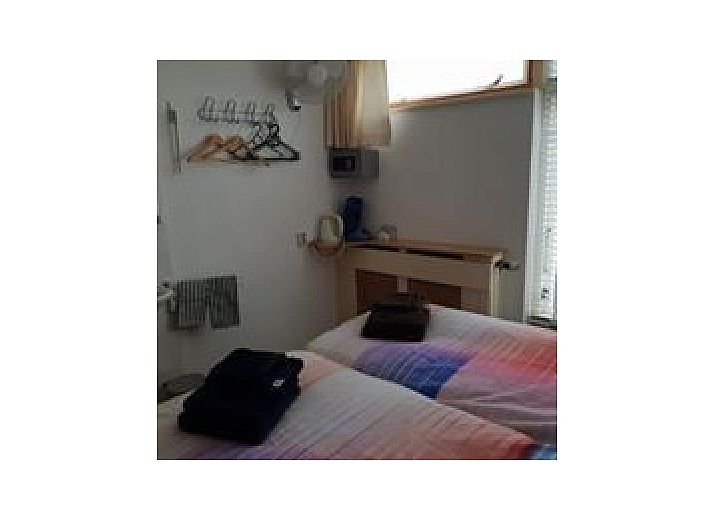 Gezellige slaapkamer met kleurrijk beddengoed bij SleepInnCallantsoog, bed and breakfast in Callantsoog aan de Noordzeekust.