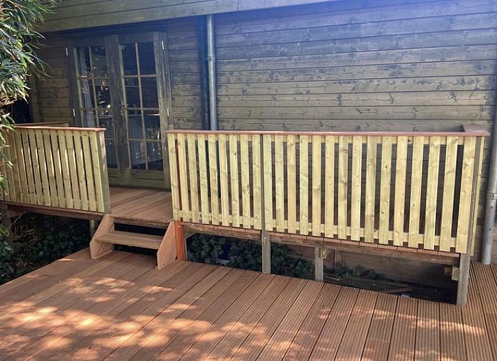 Rustiek vakantiehuis in Schellinkhout met houten veranda, gelegen aan de IJsselmeerkust.