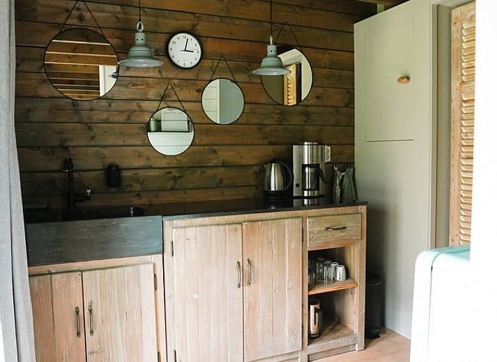 Gezellig terras bij Vakantiehuis in Schellinkhout, omgeven door weelderige natuur.