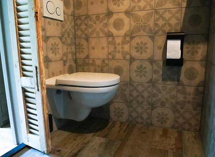 Gezellig terras bij Vakantiehuis in Schellinkhout, omgeven door weelderige natuur.