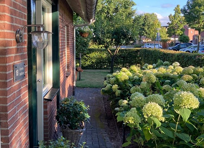 Vacation home in Oldenzaal, Twente, with charming wooden facade and red roof tiles, surrounded by lush nature.