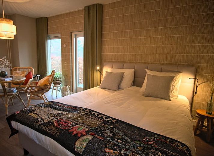 Sunny facade of Holiday Home in Oldenzaal, Twente, with solar panels and green hedge for lasting charm.