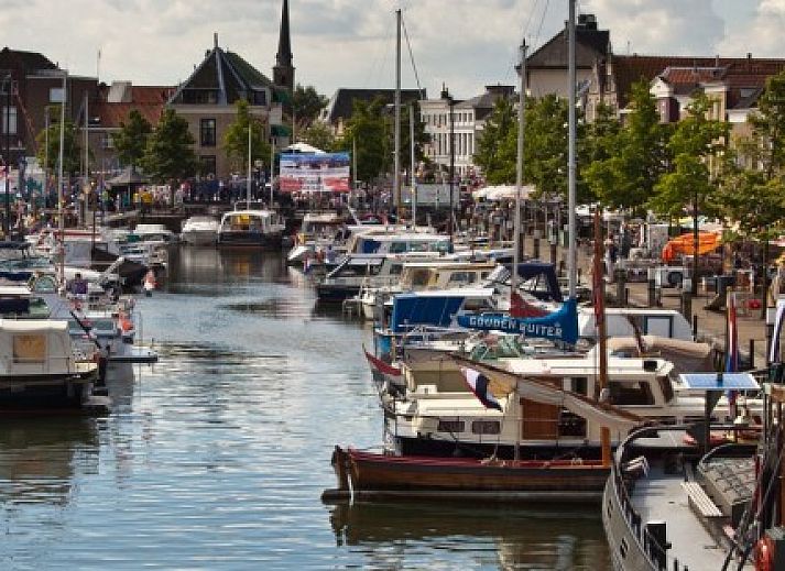 Ingang van DE DIJK bed and breakfast in Zuid-Beijerland, Zuid-Holland met bloeiende planten.