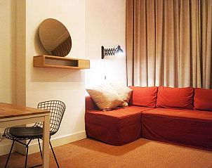 Gezellige woonkamer met rode bank bij Alberti - Bed & Bike, bed and breakfast in Rotterdam, Zuid-Holland.