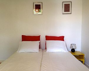Comfortabele slaapkamer bij Bed & Breakfast Maria in Rotterdam met rode en witte accenten.