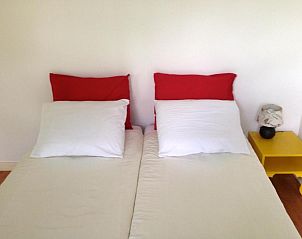 Sfeervolle slaapkamer in Bed & Breakfast Maria in Rotterdam met rode en gele accenten.