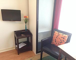Stijlvolle hoek met tv en bloemen in Bed & Breakfast Maria in Rotterdam, een oase van comfort.