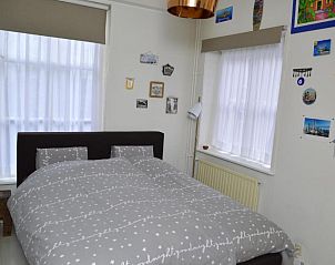 Sfeervolle slaapkamer in Bed and Breakfast de Kleyne Wereld, Vlissingen met kunst aan de muur.