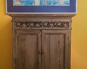 Antieke kast in Bed and Breakfast de Kleyne Wereld, Vlissingen met kunstwerk erboven.