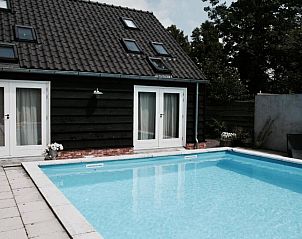 Zwembad met ligstoelen bij Bed & Breakfast Zeeland, Noordwelle, perfect voor ontspanning.