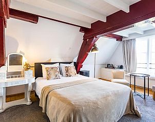 Ruime slaapkamer met houten balken in B&B Parijs aan de Kaai, Middelburg.