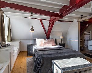 Comfortabele slaapkamer met houten elementen in B&B Parijs aan de Kaai, Zeeland.