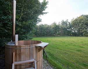 Houten hot tub bij Vakantiehuis in Diever, Zuidwest Drenthe, met uitzicht op het groene landschap voor ontspanning.