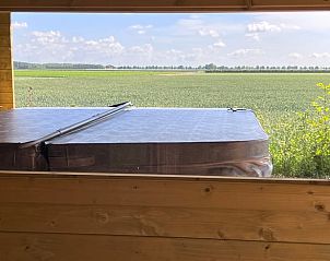 Panoramisch uitzicht op velden vanuit de jacuzzi bij Vakantiehuisje in Kraggenburg, Flevoland.