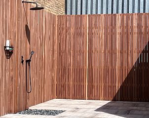 Ruime buitendouche met houten afwerking bij Vakantiehuisje in Kraggenburg, Flevoland.