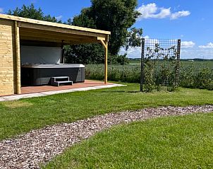 Veranda met jacuzzi en uitzicht op velden bij Vakantiehuisje in Kraggenburg, Oostelijk Flevoland.