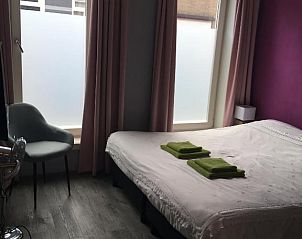 Lichte slaapkamer met grote ramen in Vrije Vlinders bed and breakfast, Ijzendijke, Zeeland.