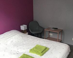 Gezellige slaapkamer met kleurrijke accenten in bed and breakfast Vrije Vlinders, Ijzendijke, Zeeuws-Vlaanderen.