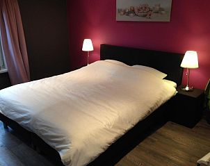 Ruime slaapkamer met sfeervolle verlichting in bed and breakfast Vrije Vlinders, Ijzendijke, Zeeuws-Vlaanderen.