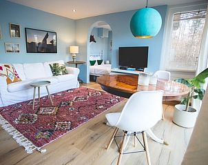 Gezellige woonkamer in Vakantiehuisje in Hoenderloo, Veluwe, met kleurrijke inrichting en comfortabele zitruimte.