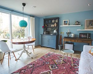 Eetkamer in Vakantiehuisje in Hoenderloo, Veluwe, met uitzicht op de tuin en een uitnodigende sfeer.