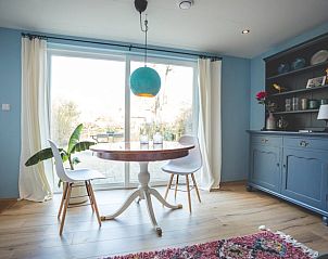 Lichte eetruimte in Vakantiehuisje in Hoenderloo, Veluwe, met toegang tot de tuin en veel natuurlijk licht.