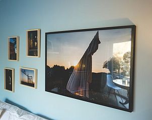 Wanddecoratie in Vakantiehuisje in Hoenderloo, Veluwe, met artistieke foto's en schilderijen.
