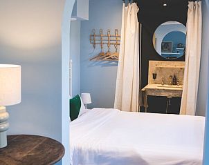 Slaapkamer in Vakantiehuisje in Hoenderloo, Veluwe, met een comfortabel bed en sfeervolle verlichting.