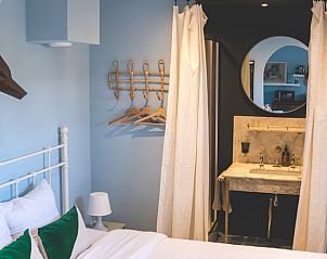 Stijlvolle slaapkamer in Vakantiehuisje in Hoenderloo, Veluwe, met moderne inrichting en zachte kleuren.