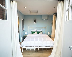 Luxe bed in Vakantiehuisje in Hoenderloo, Veluwe, met frisse lakens en uitnodigende uitstraling.