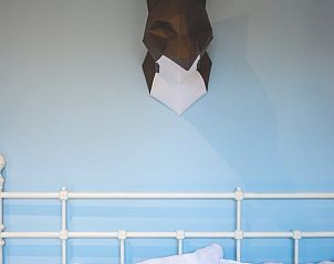 Unieke wanddecoratie boven het bed in Vakantiehuisje in Hoenderloo, Veluwe, met moderne kunst.