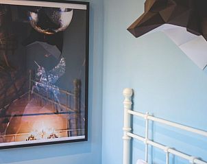 Artistieke details in de slaapkamer van Vakantiehuisje in Hoenderloo, Veluwe, met een moderne touch.