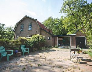Terras bij Vakantiehuisje in Hoenderloo, Veluwe, met comfortabele stoelen en uitzicht op de natuur.