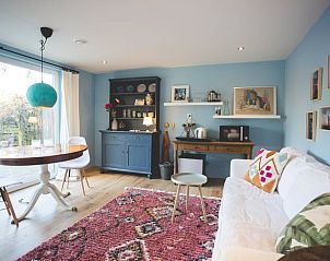 Veranda van Vakantiehuisje in Hoenderloo, Veluwe, met uitnodigende sfeer en natuurlijke omgeving.