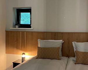 Sfeervolle slaapkamer in Vakantiehuisje in Vaassen, Veluwe, met houten details en natuurlijk licht.