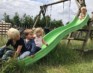 Kinderen spelen op glijbaan bij Huisje in Oosterwolde, bed and breakfast op de Veluwe.