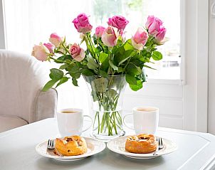 Verse rozen en koffie in Vakantiehuisje in Uddel, Veluwe, zorgen voor een warm welkom.